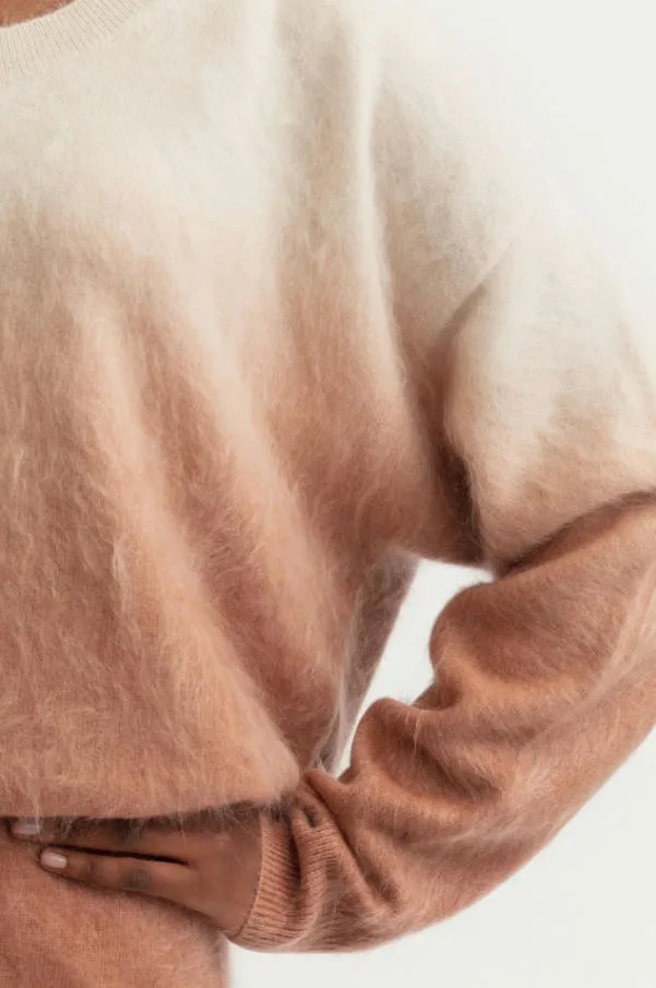 Close-up texture shot of gradient dip-dye brushed cashmere crew neck sweater, peach to off-white ombre fuzzy halo cashmere knit fabric detail, soft brushed fleece women pullover texture photo