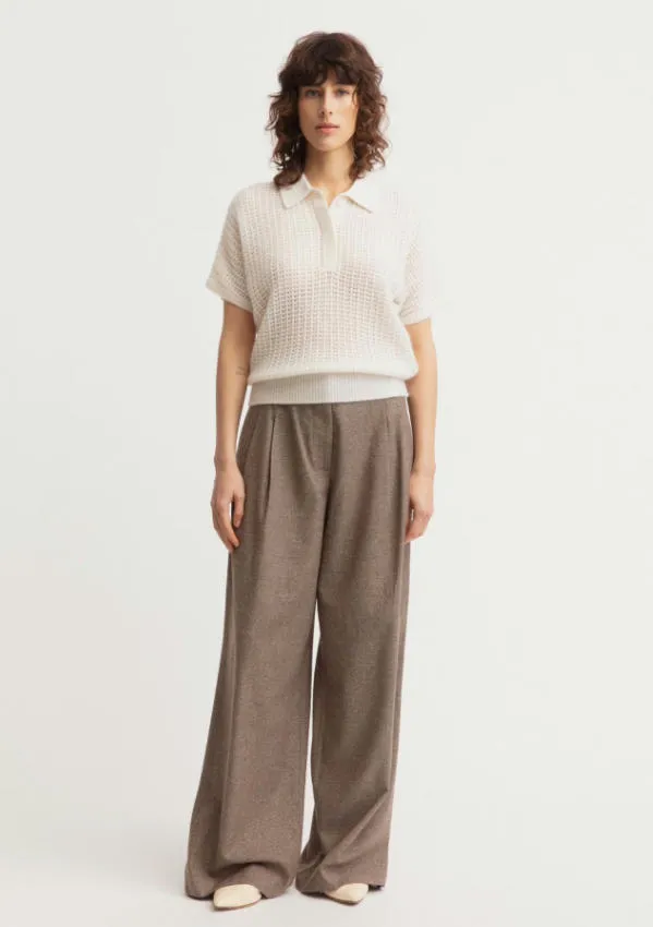 Full body studio look of off-white cashmere cotton openwork short sleeve polo sweater matched with taupe wide leg wool trousers, breathable mesh knit collared top minimalist business casual women outfit