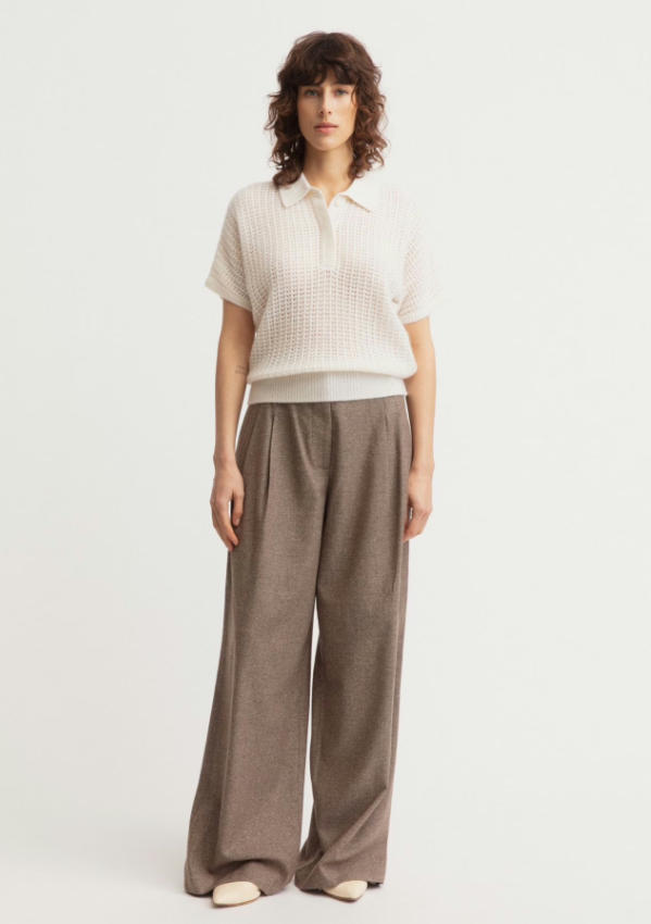 Full body studio look of off-white cashmere cotton openwork short sleeve polo sweater matched with taupe wide leg wool trousers, breathable mesh knit collared top minimalist business casual women outfit