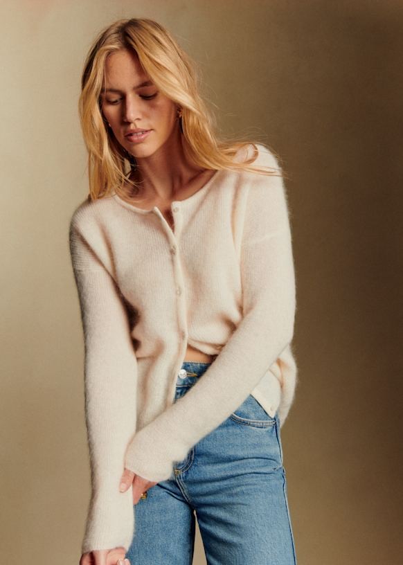 Full body studio fashion shot of cream ultra-fine 50% kid mohair crew neck cardigan, lightweight wispy fuzzy halo knit outerwear, minimalist French casual knitwear paired with blue jeans