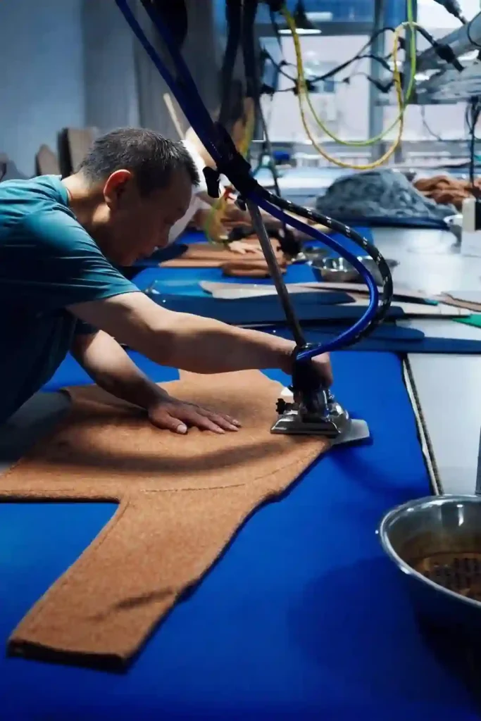 Factory worker ironing cashmere fabric panel, pre-finishing process for cashmere sweater, cashmere grade A B C guide